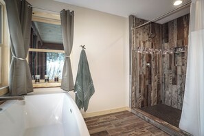 A bathroom with a shower, a bathtub, and a window with curtains. - A remote private mountain retreat complete with a 4WD 4 seat side by side (Bridger)