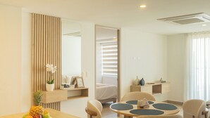 Ein Hotelzimmer mit Essbereich, einem Bett, einem Badezimmer und Blick nach draußen.