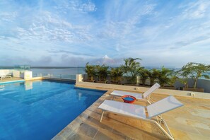 A rooftop pool with clear blue water, surrounded by lounge chairs and potted plants. - Oceani Towers Cielo Mar · Rooftop, beach 5 min (Cartagena de Indias)