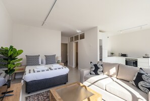 A modern bedroom with a bed, bedside table, and a large window. - Bright City Studio in the Heart of Cape Town (Cape Town)