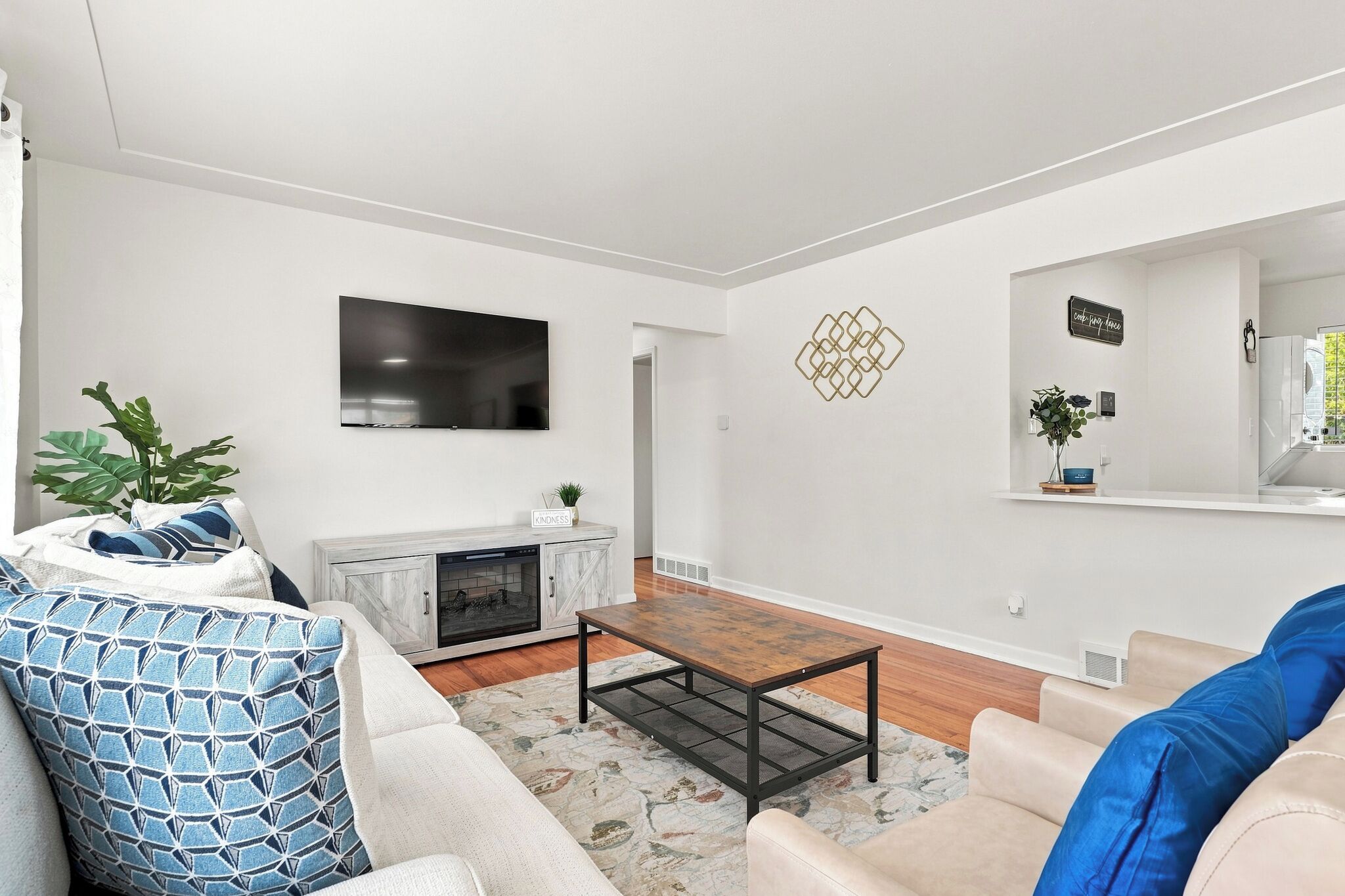 A modern living room with a fireplace, a flat-screen TV, and a comfortable seating area.