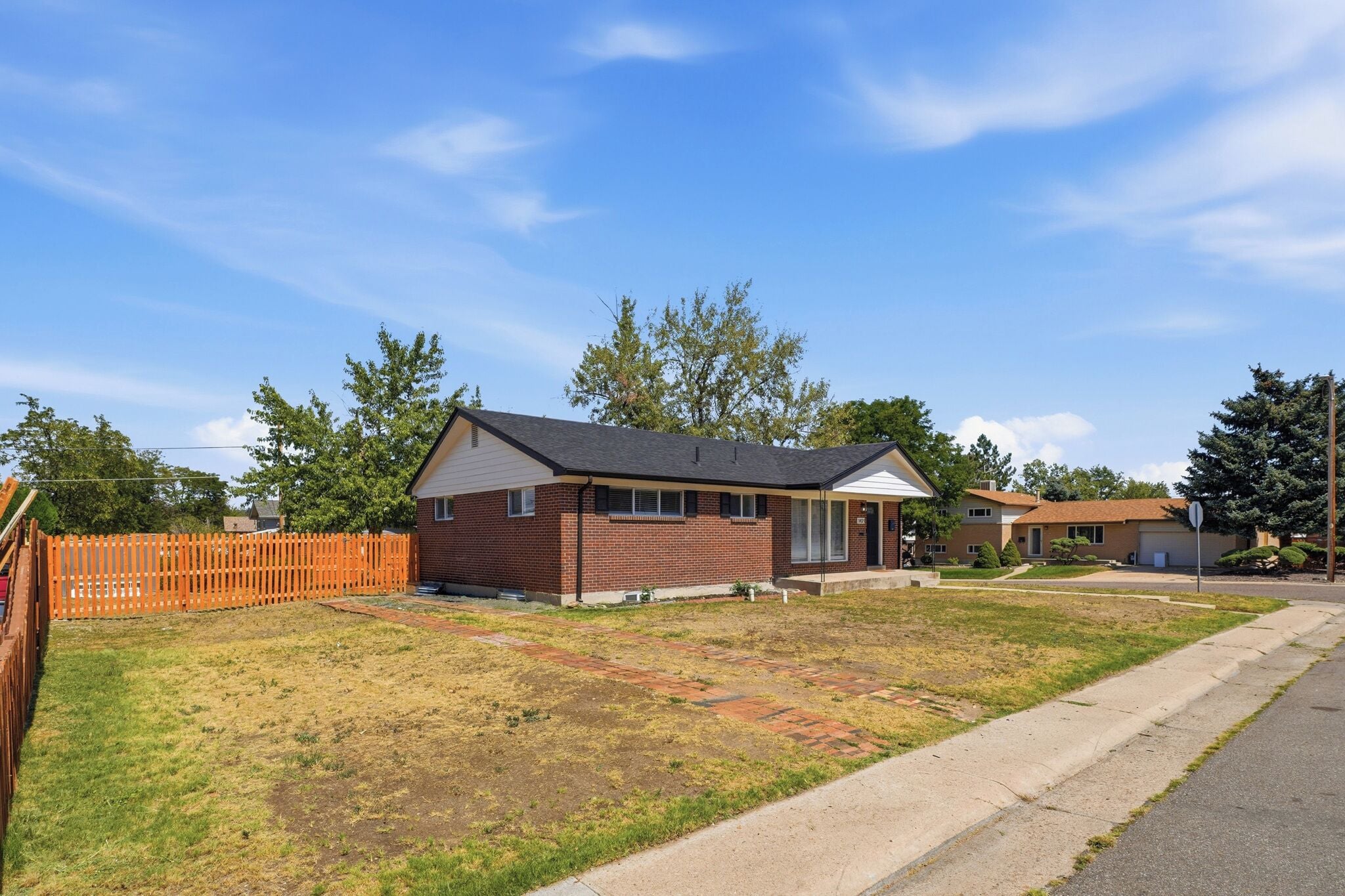 A single-story brick house with a front porch and a small front yard.