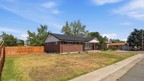 A single-story brick house with a front porch and a small front yard.