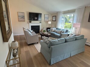 A living room with a fireplace, a television, and a sofa.