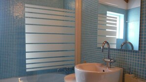 Ein Badezimmer mit einer Badewanne, einem Waschbecken und einem Spiegel.
