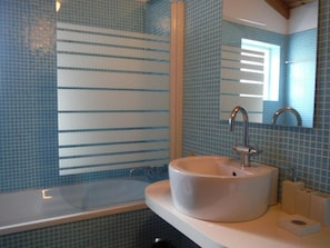 A bathroom with a bathtub, a sink, and a mirror. - Quinta da Ribeira da Urze (Prainha de Cima Azores)