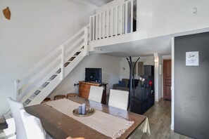 Una cocina moderna con comedor, una escalera y una sala de estar.