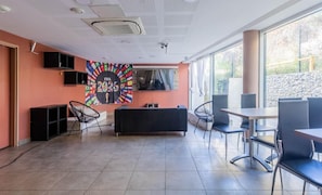 A modern indoor space with a sofa, chairs, a table, and a large window. - À 5km de Montpellier | Piscine sur place | Clim (Saint-Jean-de-Védas)