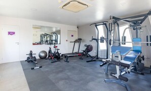A gym with exercise equipment, a mirror, and a door labeled 'SPA'.
