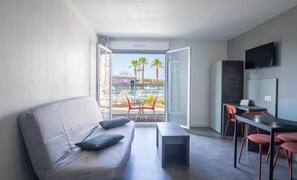 Una sala moderna con un sofá, una mesa de centro y un comedor con sillas.