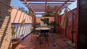 A patio with a table and chairs, a pergola, potted plants, and a decorative fence. - Central location | Private terrace | AC & Wifi (Málaga)