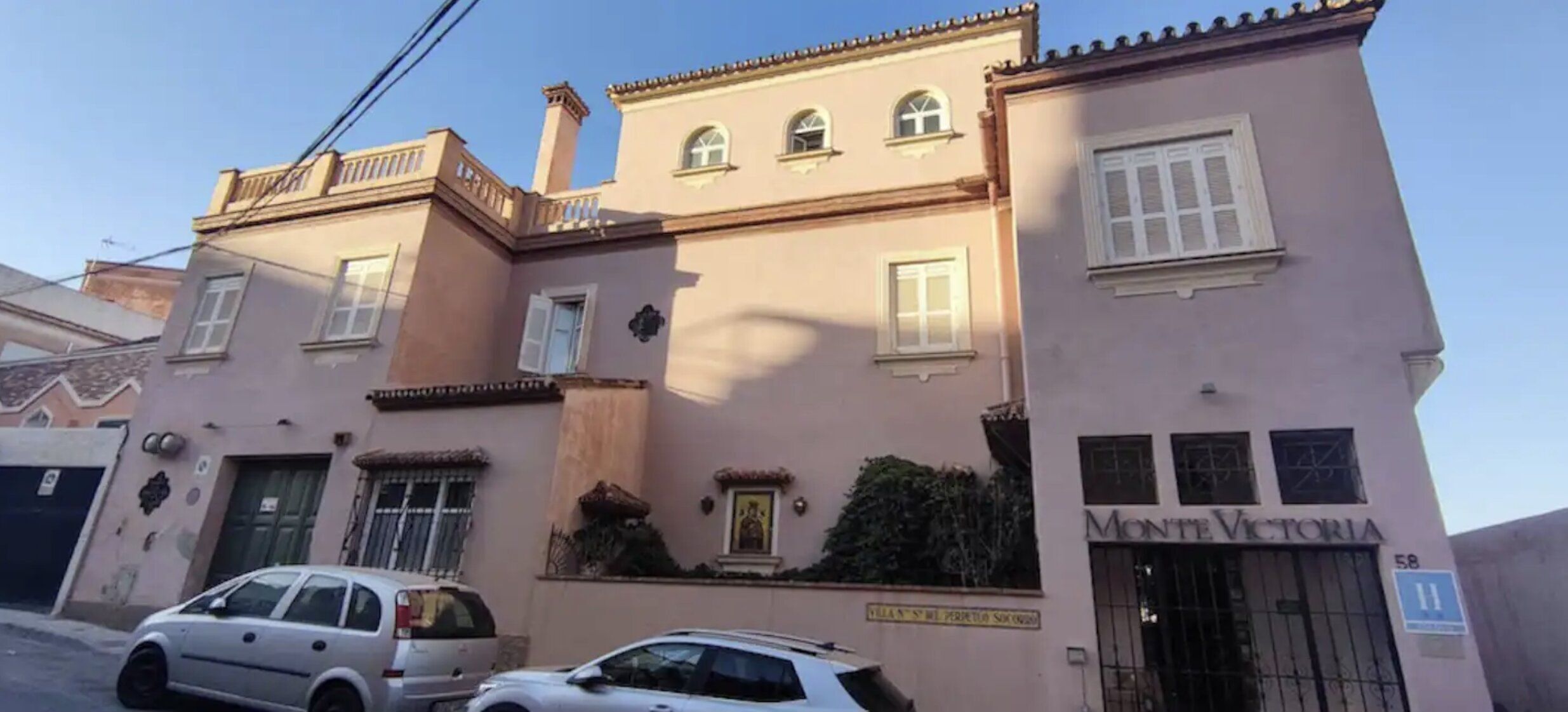 Un edificio rosa con un letrero que dice "Monte Victoria" y un número de puerta "58".