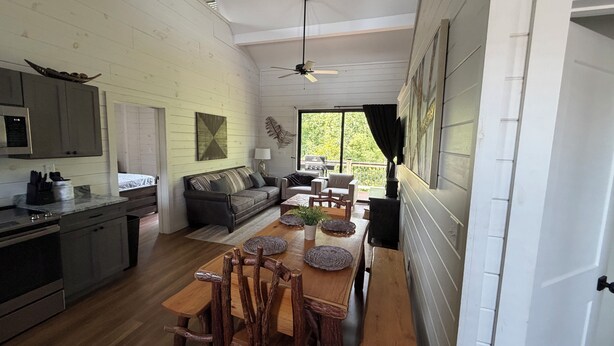 A spacious kitchen with a dining area, wooden furniture, and a ceiling fan. - Serene 3-bedroom house with AC in beautiful Sevierville (Sevierville)