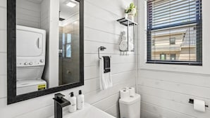 A modern bathroom with a large mirror, a sink, a towel rack, and a window with blinds. - Serene 3-bedroom house with AC in beautiful Sevierville (Sevierville)
