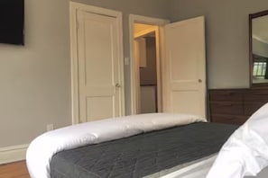 A bedroom with a bed, a dresser, and a mirror.