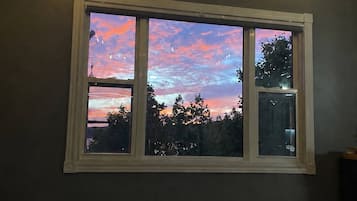 Ein Schlafzimmer mit großem Fenster, einem Bett und einem Heizgerät.