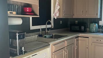 A kitchen with a dishwasher, sink, and microwave.