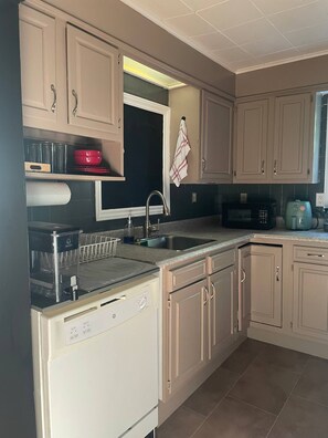 A kitchen with a dishwasher, sink, and microwave.