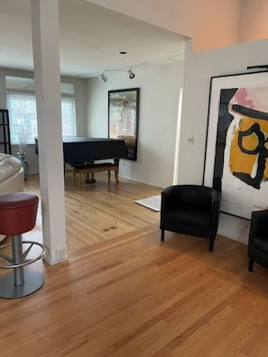 Ein Wohnzimmer mit Billardtisch, einem schwarzen Sessel und einem gerahmten Kunstwerk an der Wand.
