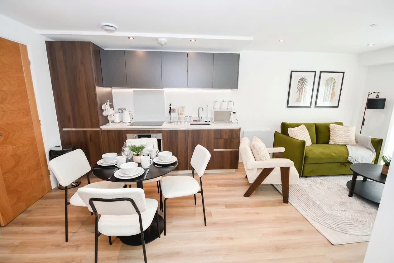 A modern living space with a dining area, kitchen, and seating area.