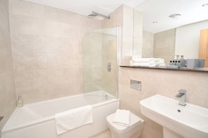 Ein modernes Badezimmer mit einer Duschkabine, einer weißen Badewanne, einem Waschbecken und einer Toilette.