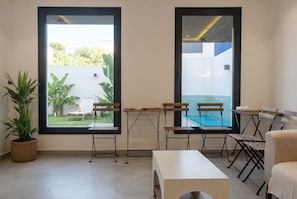 Ein Zimmer mit einem großen Fenster, einem weißen Tisch und einer Bank.