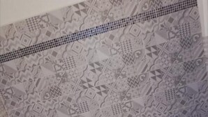 Een badkamer met een bad, betegelde vloer en een toilet.