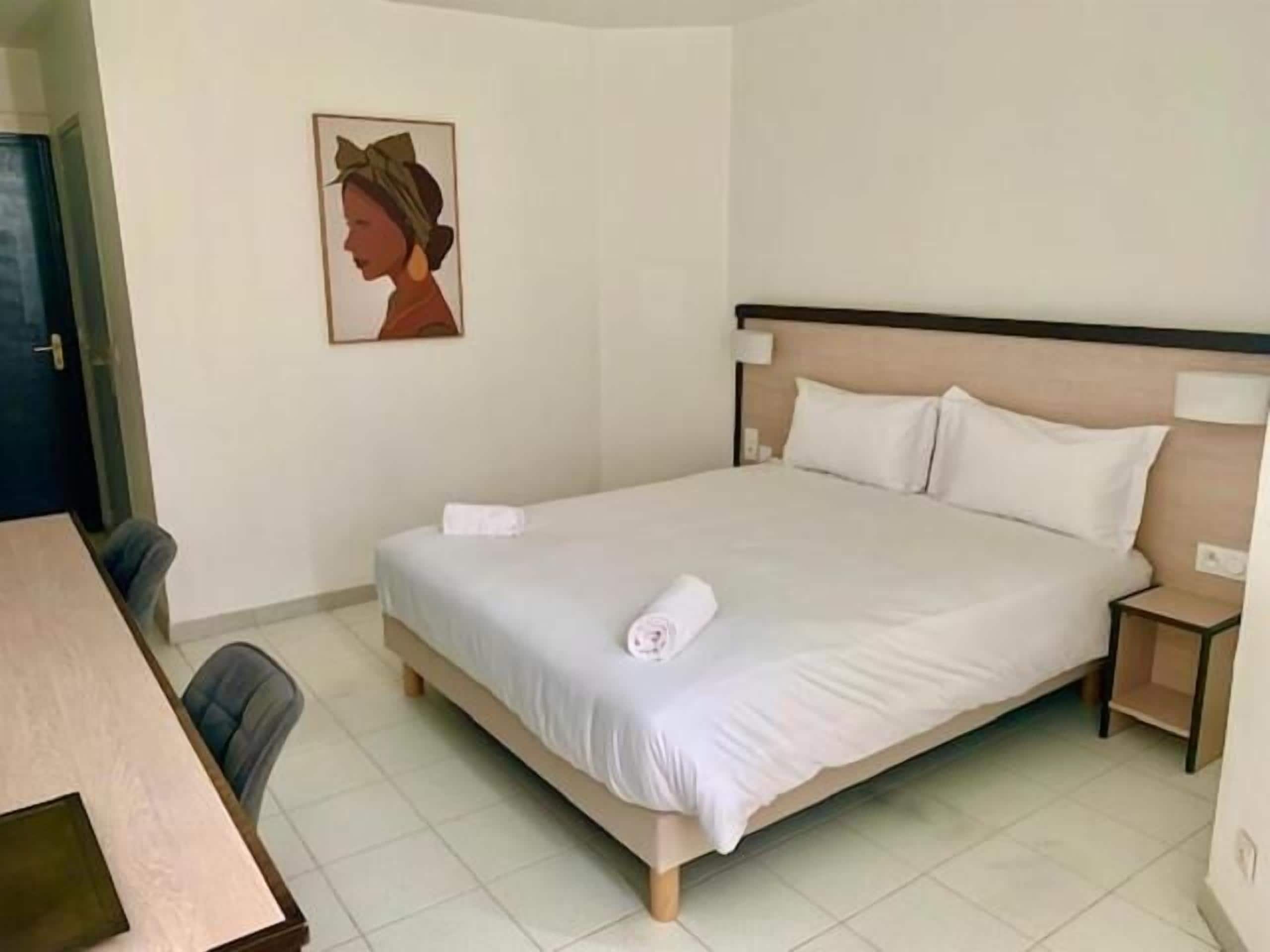 Una habitación de hotel con una cama individual, un escritorio y una silla.