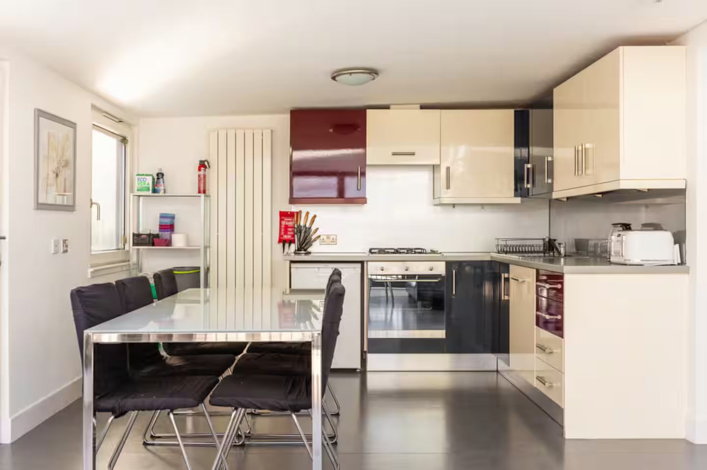 Une cuisine moderne équipée d’une table à manger, de chaises, d’une cuisinière, d’un four, d’un four à micro-ondes et de placards.