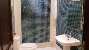 Une salle de bain comprenant des toilettes, un lavabo et un espace douche.
