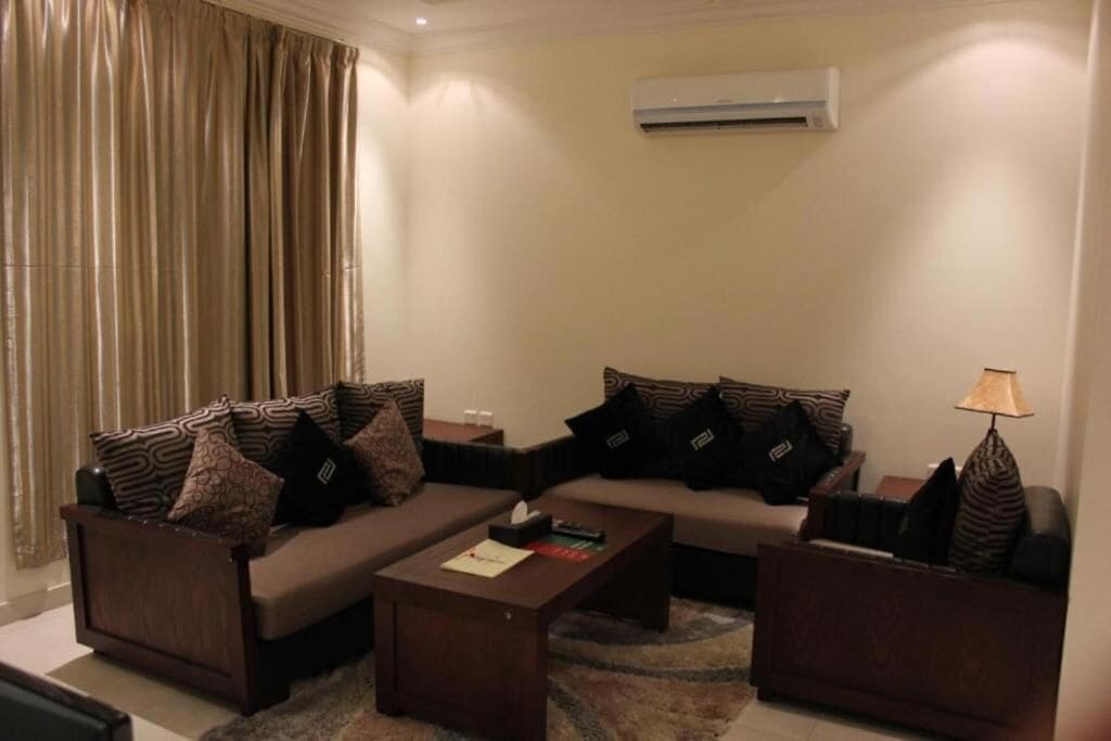 A living room with two sofas, a coffee table, and a lamp.