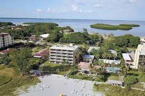 A coastal hotel with multiple buildings, a beach area, and a view of the sea. - Beachfront I Private Deck I Pool I Villa 83 (Longboat Key)