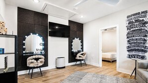 Een moderne kamer met een kaptafel, spiegels en een decoratieve wand met tekst.