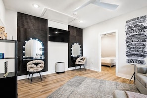 A modern room with a vanity, mirrors, and a decorative wall with text. - The Chatterbox, Pool, 4BR by Velvet Ditch Villas (Oxford)