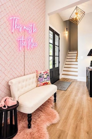 A modern interior with a neon sign, a sofa, a fluffy rug, and a staircase. - The Chatterbox 2mi 2 Sq & Campus VelvetDitchVillas (Oxford)