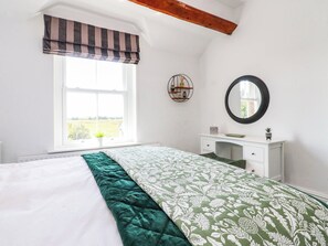 A bedroom with a bed, a window, a dresser, and a mirror. - The Swallows (Lancaster)