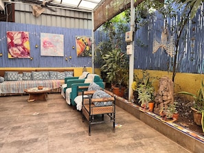 An outdoor seating area with a sofa, chairs, and a small table.