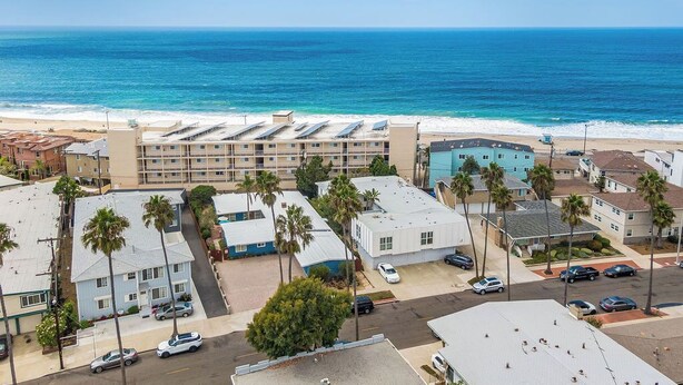 Hotel à beira-mar com vários edifícios, estacionamento e vista para a praia.