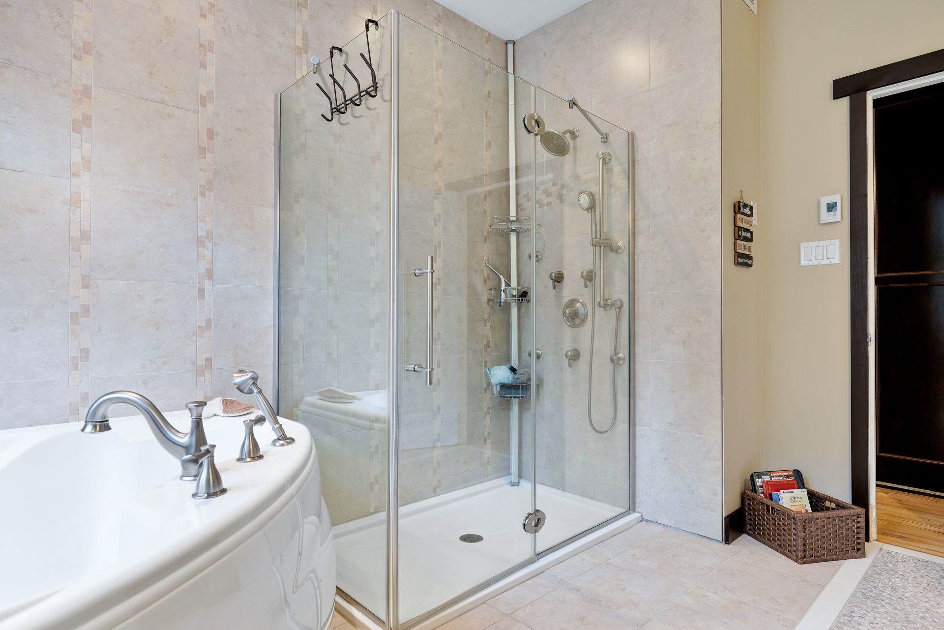Un baño moderno con ducha envuelta en vidrio, una bañera blanca y un lavamanos con múltiples grifos.
