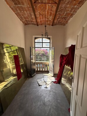A room with a brick ceiling, a large window with a view of a balcony, and a red curtain. - Zacatecas 167, Industrial charm and vintage style in the heart of Roma Norte (Ciudad de México)