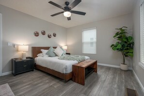 A bedroom with a bed, bedside tables, a ceiling fan, wall decorations, a window with blinds, and a potted plant. - Relax In Sedona/Thunder Mountain View-FLAT (Sedona)