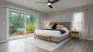 A bedroom with a bed, bedside tables, a ceiling fan, and a view of a balcony. - Relax In Sedona/Thunder Mountain View-FLAT (Sedona)
