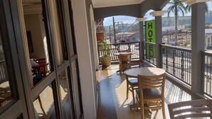 Ein Balkon mit Blick auf eine Straße, ein Schild mit der Aufschrift 'HOT' und Außenplätze.