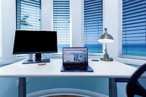 A modern office desk with a computer monitor, laptop, and desk lamp. - BeachRentalCarlsbad - 180° Ocean Views - 5 Min Walk to the Beach - Sleeps 7 (Carlsbad)