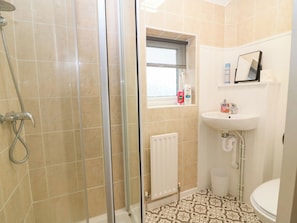 A bathroom with a shower, a sink, and a toilet. - Hill View Studio (Hawick)