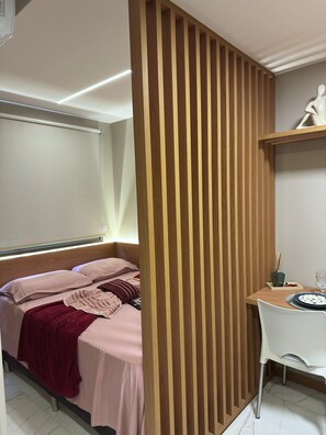 A bedroom with a bed, a desk, and a chair. - Costa Azul 109 (Salvador)