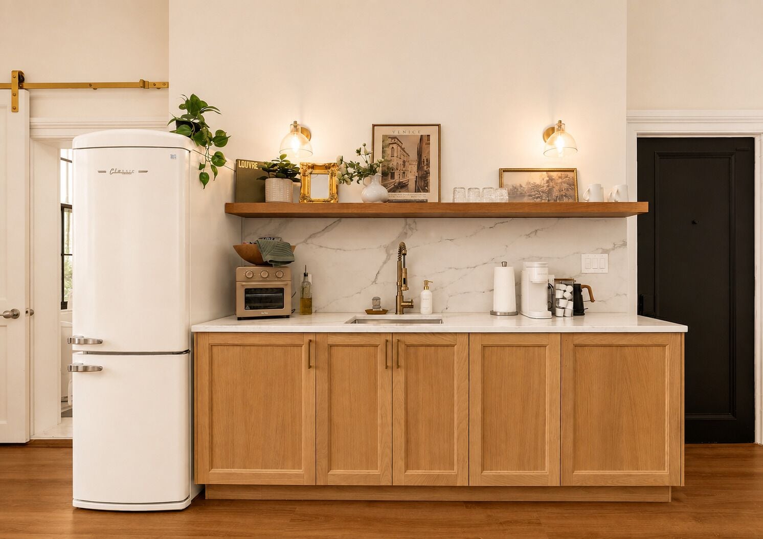 A kitchen with wooden cabinets, a white refrigerator, a coffee maker, and a shelf with decorative items.