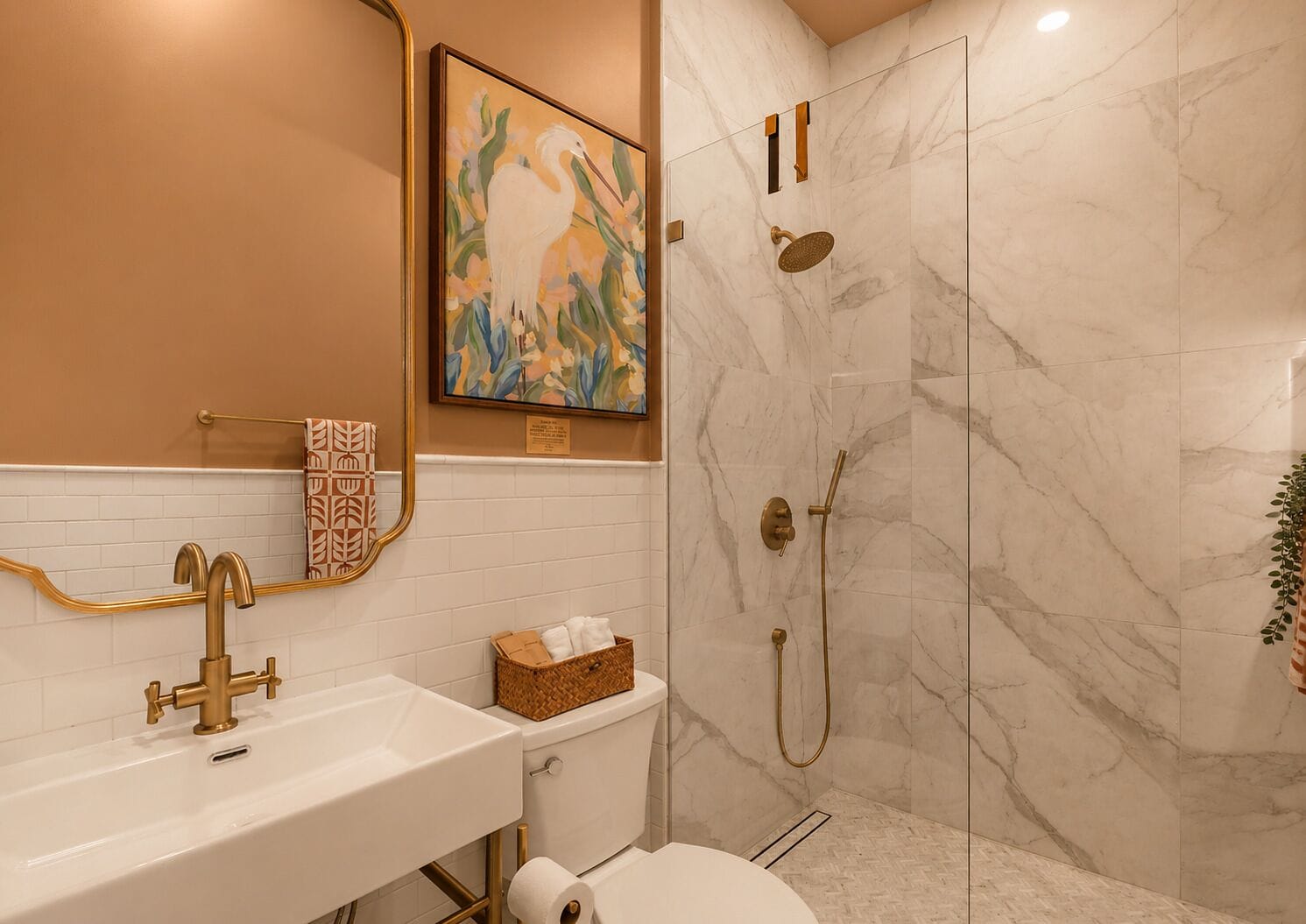 A bathroom with a white sink, gold fixtures, a glass-enclosed shower, and a framed artwork on the wall.