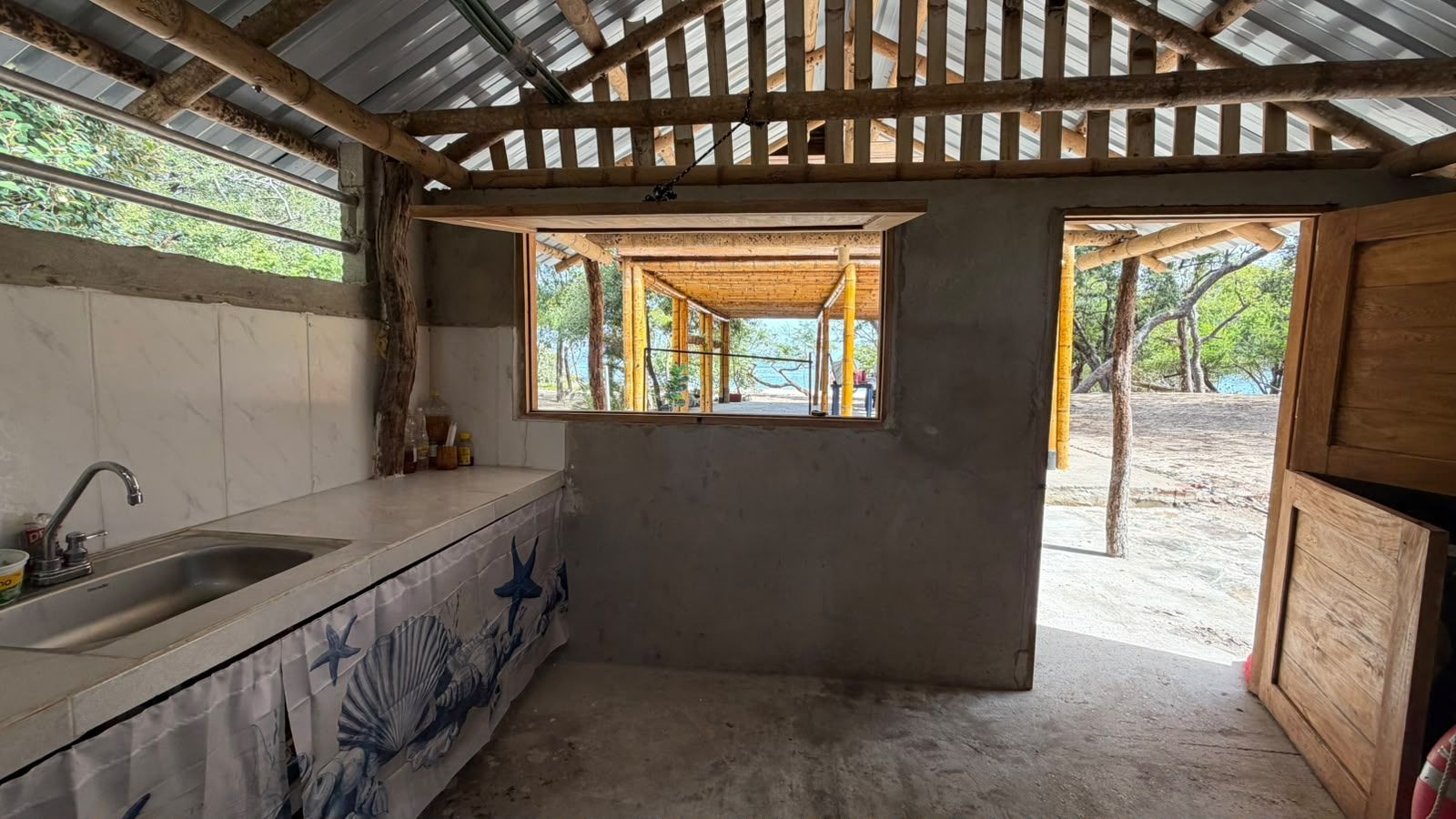 Una cocina con un lavamanos, una ventana y vistas al exterior.