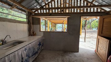 Una cocina con un lavamanos, una ventana y vistas al exterior.